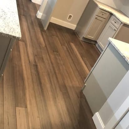 A kitchen with hardwood floors and white cabinets.