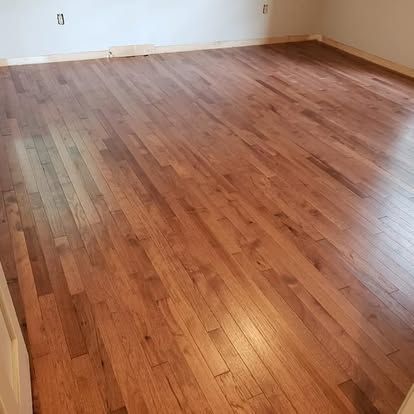 A large room with a wooden floor and a white wall.