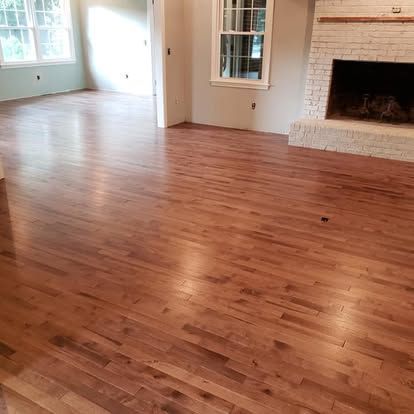A living room with hardwood floors and a fireplace.