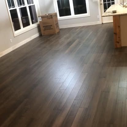 A living room with hardwood floors and a box on the floor.