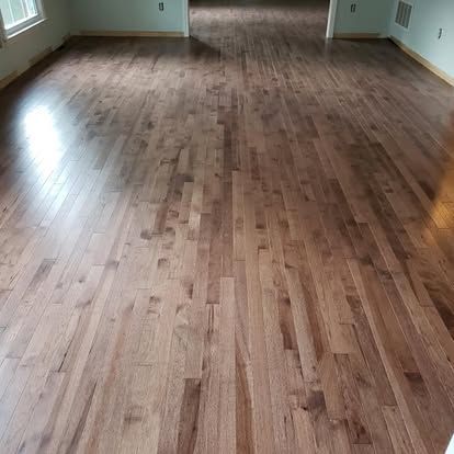 A living room with a wooden floor and a window.