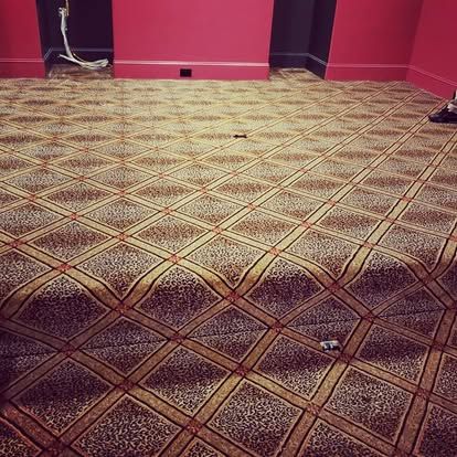 A carpeted floor in a room with a pink wall.