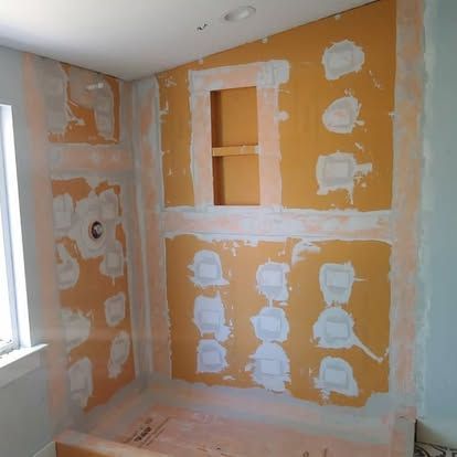 A bathroom under construction with a bathtub and a window.