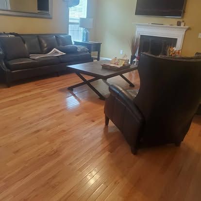 A living room with a couch , chair , coffee table and fireplace.