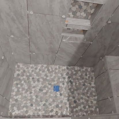 A bathroom with a walk in shower and a tiled floor.