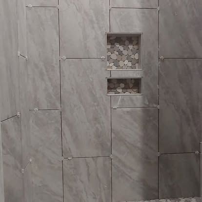 A bathroom with a tiled wall and a shower niche.