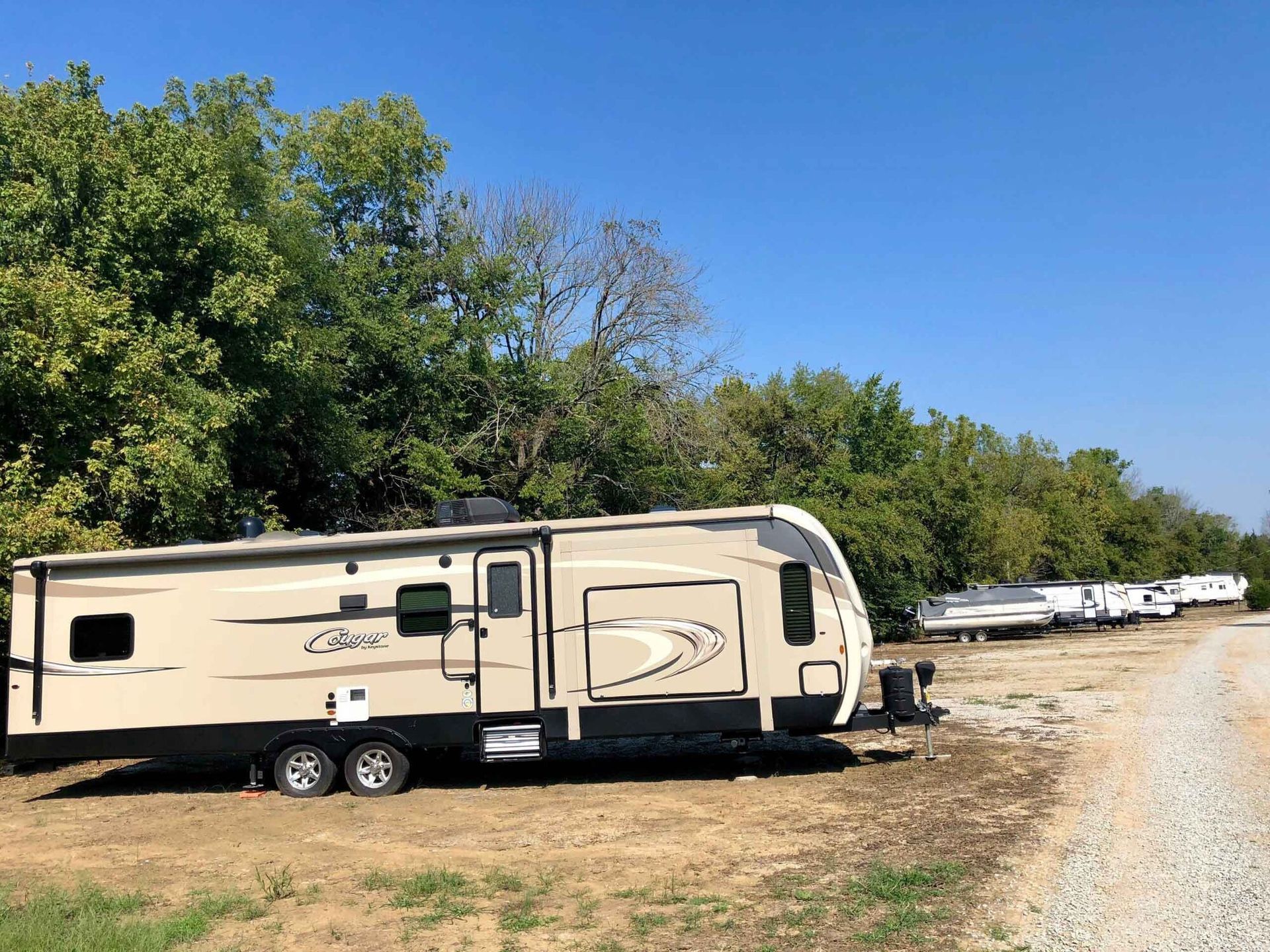 a trailer is parked on the side of a dirt road .