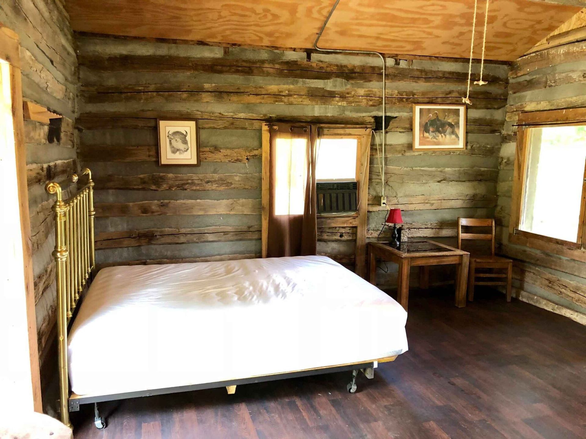 a bedroom in a log cabin with a bed , table and chairs .