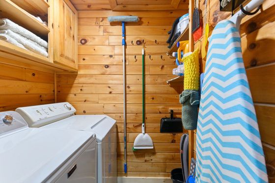 A laundry room in a log cabin with a washer and dryer.