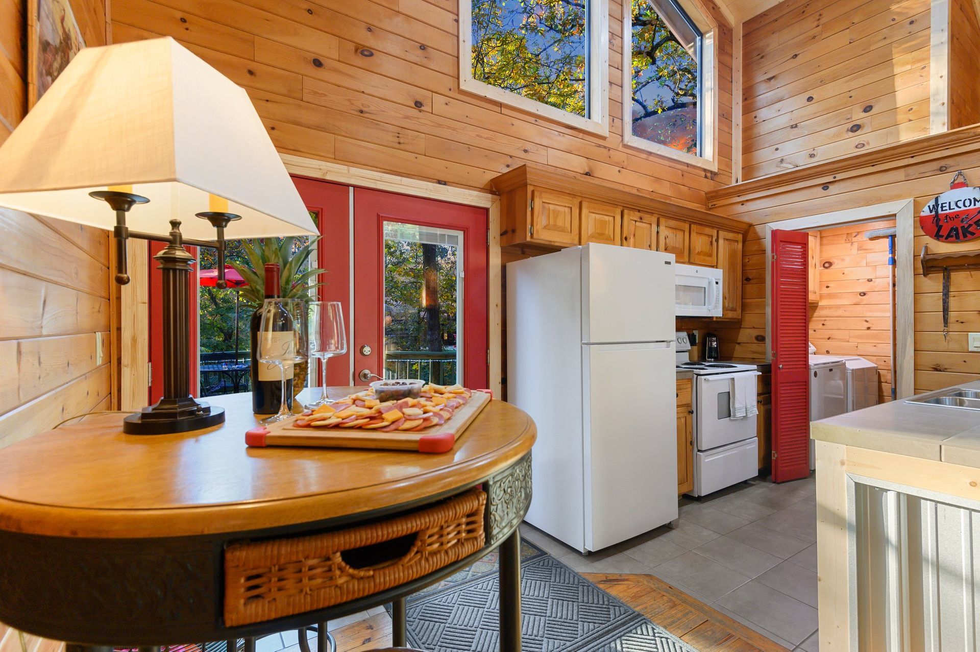 A table with a lamp and a pizza on it in a kitchen.