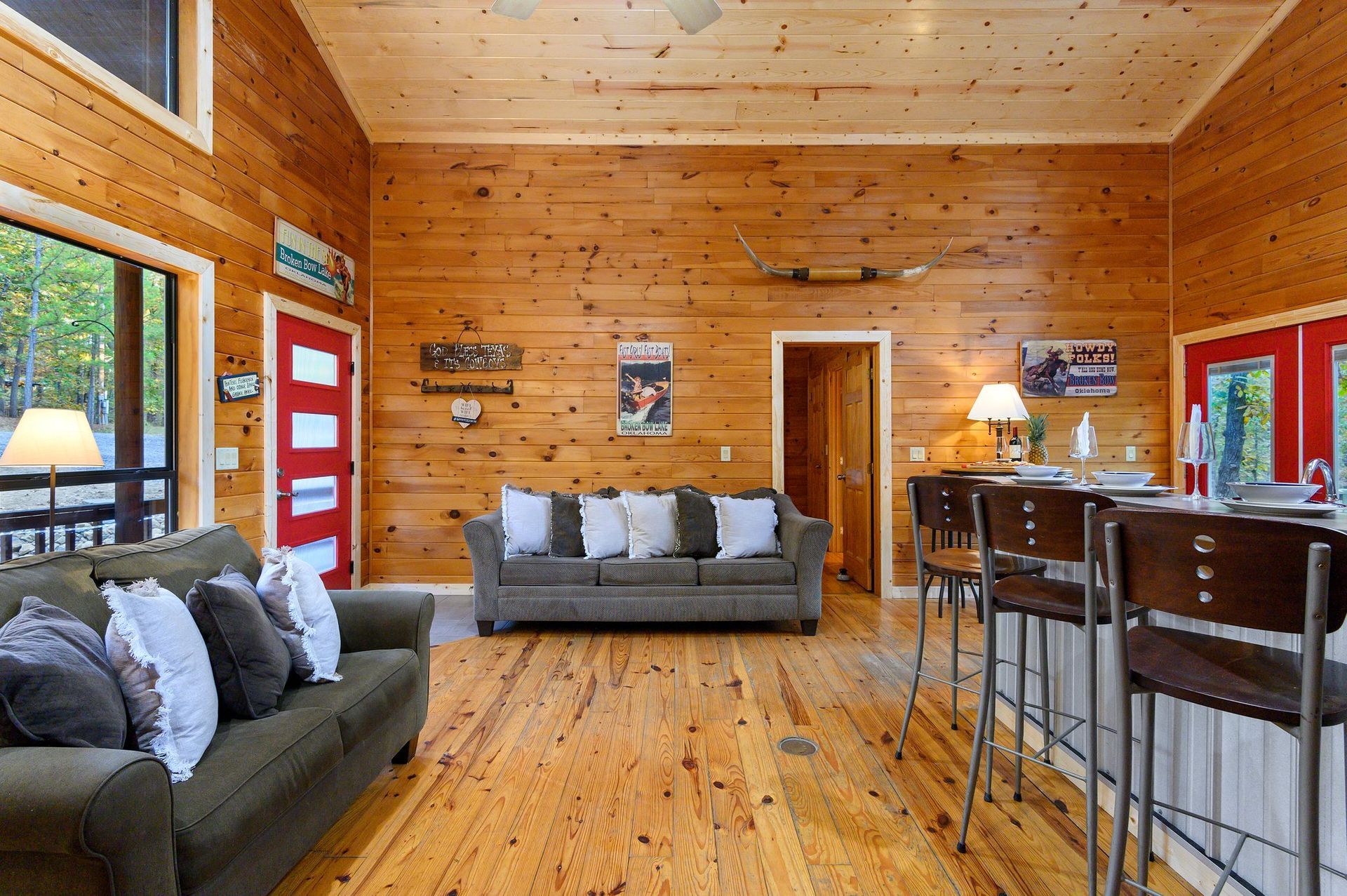 A living room with a couch and a bar in a log cabin.