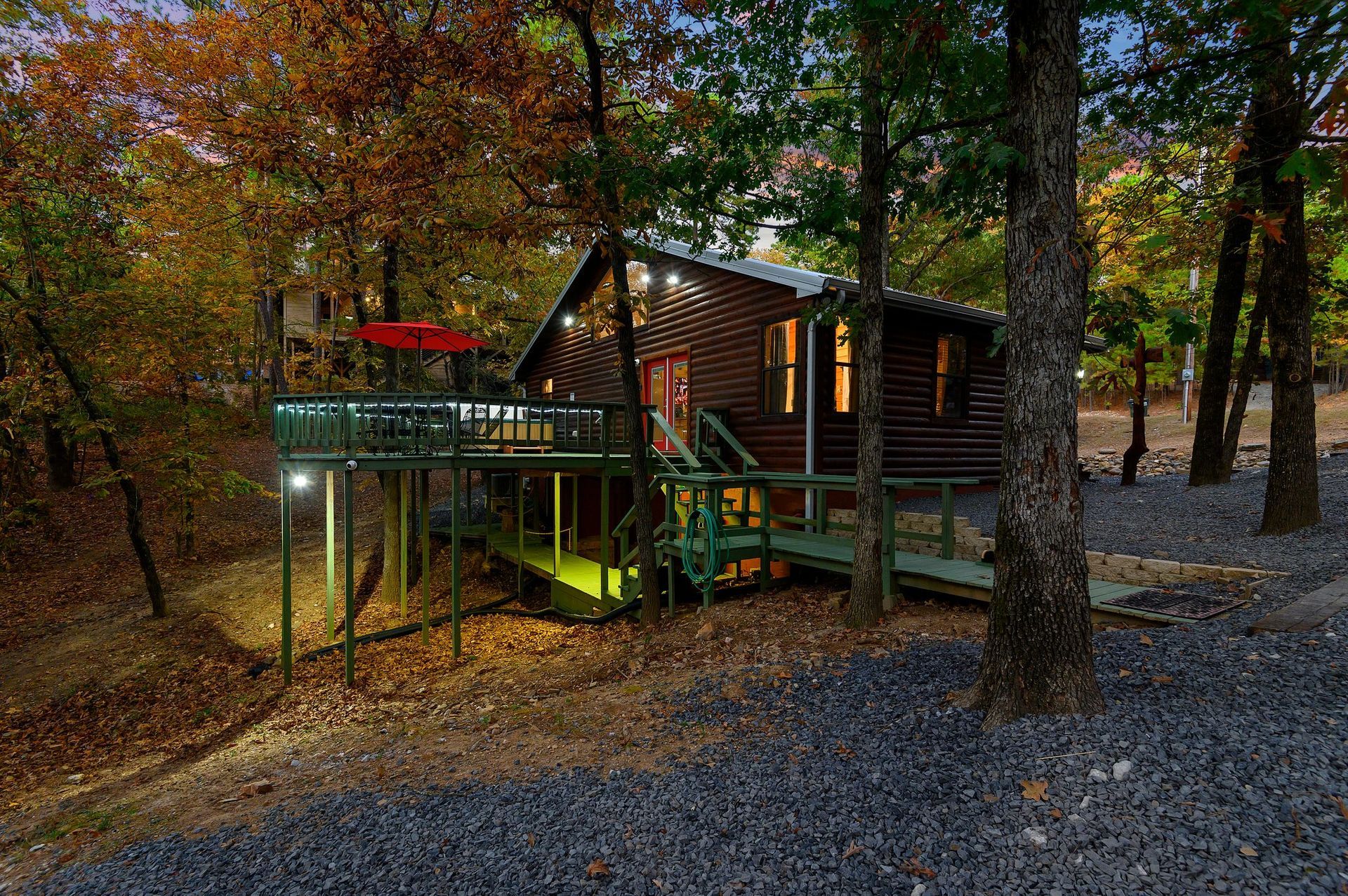 A log cabin with a tree house attached to it in the woods.