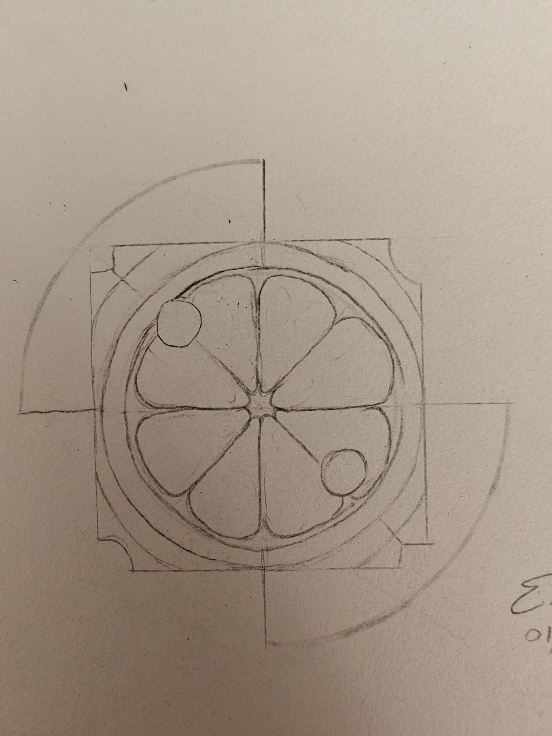 A pencil sketch on paper showing a circular geometric pattern resembling a flower or citrus slice inside a square border.