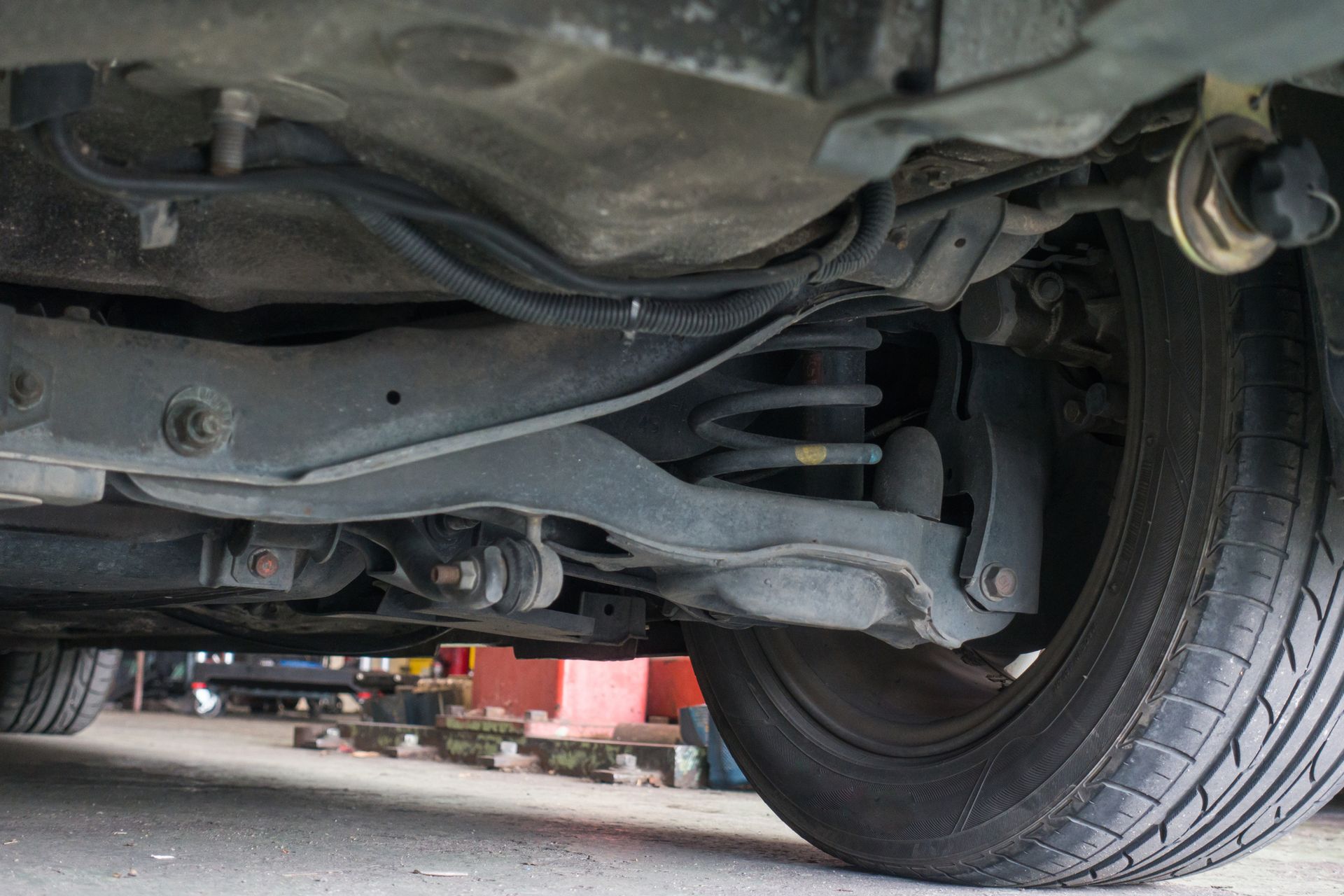 A close up of the underside of a car with a tire.