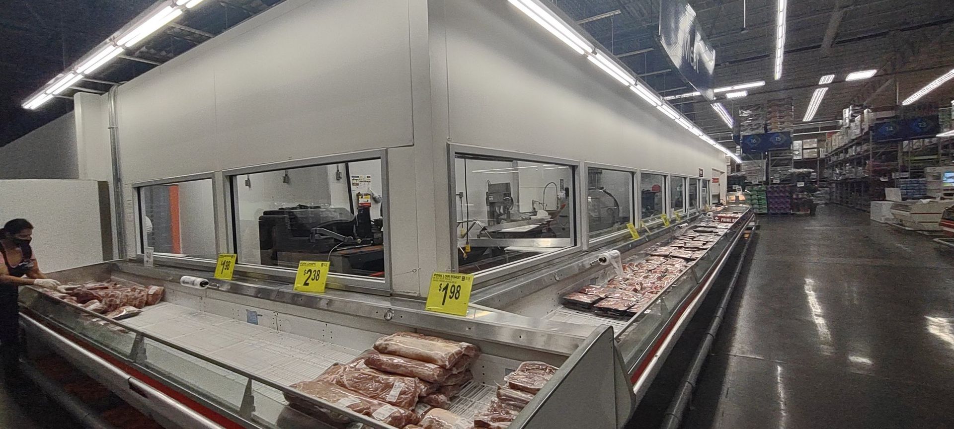 Supermarket meat case with packaged cuts on display under bright store lights