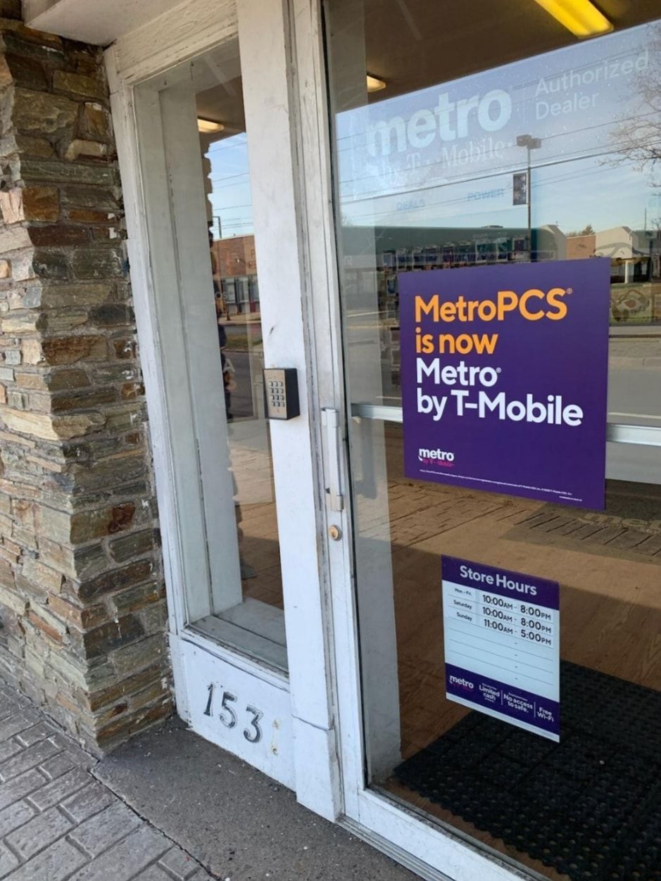 Storefront window with MetroPCS by T-Mobile sign and a white door