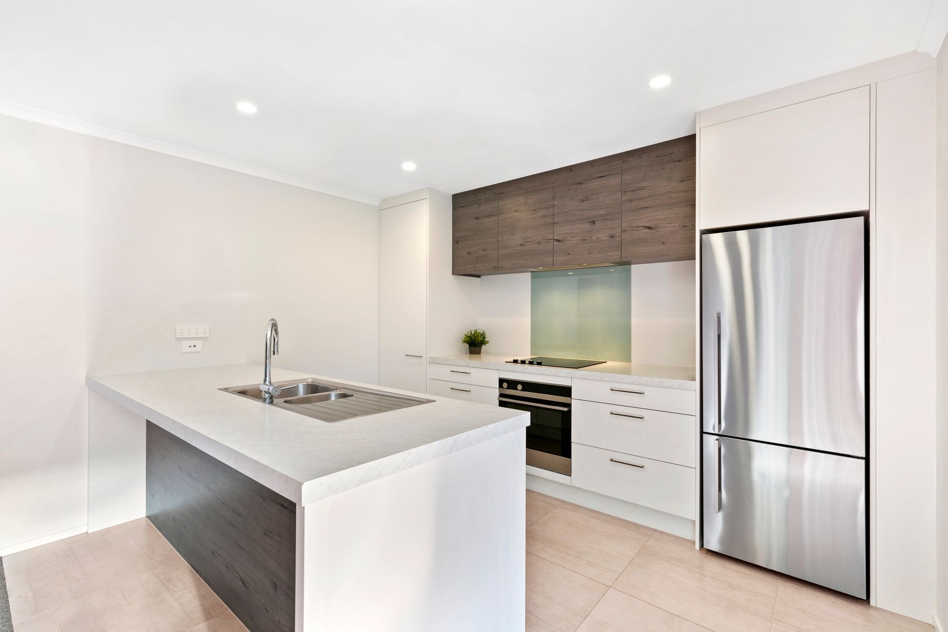 A kitchen with stainless steel appliances and a stainless steel refrigerator.