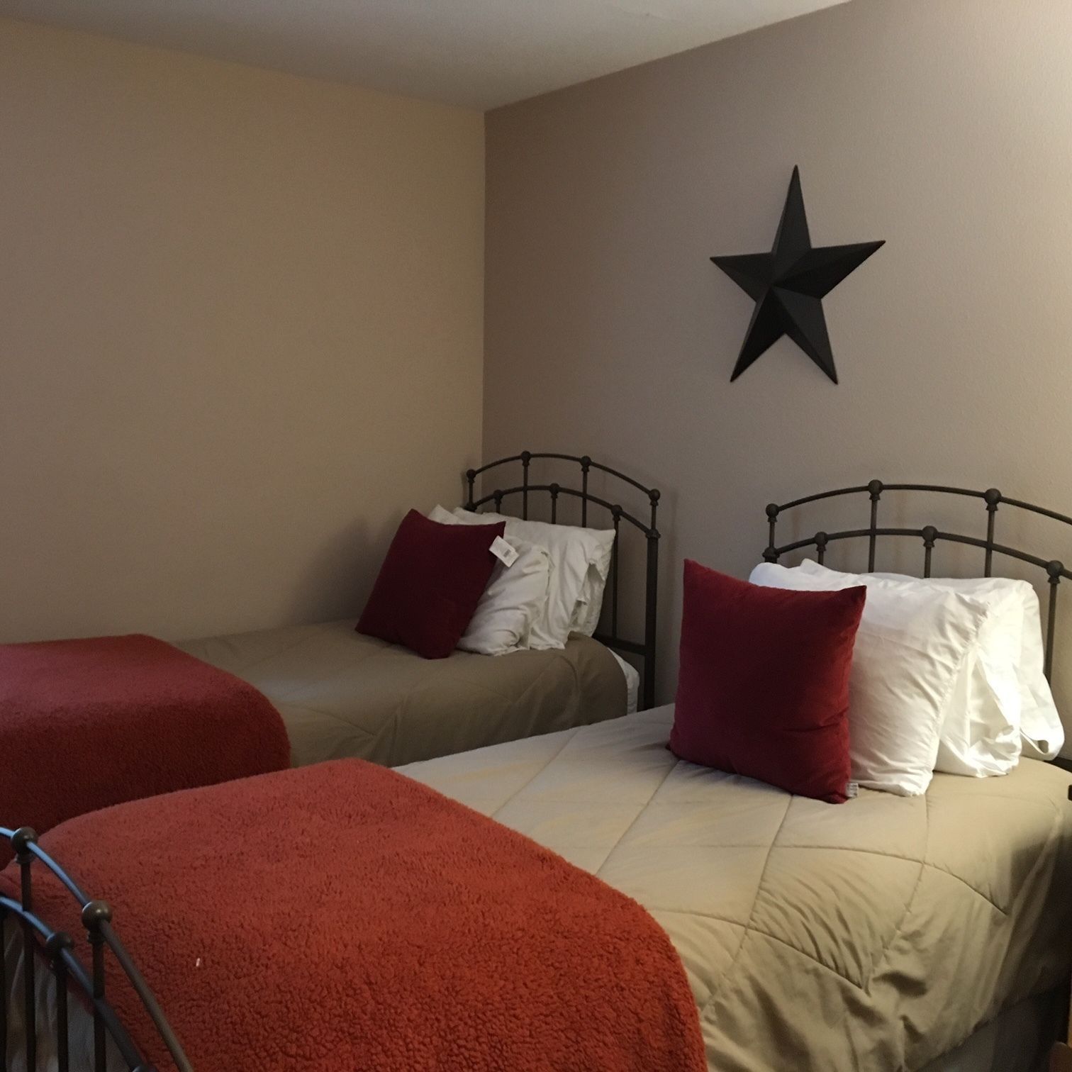 A bedroom with two beds and a star on the wall