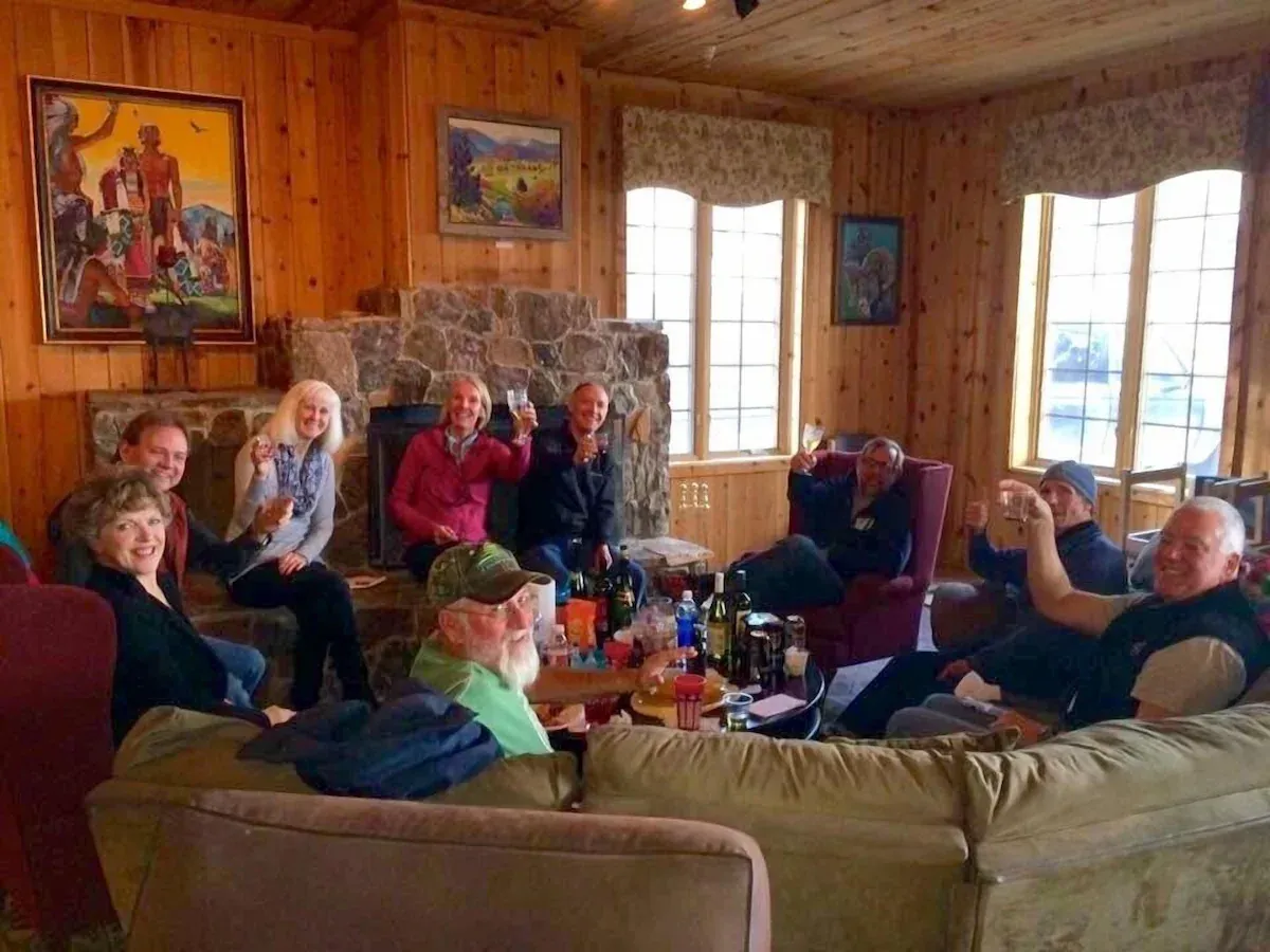 A group of people are sitting around a table in a living room.