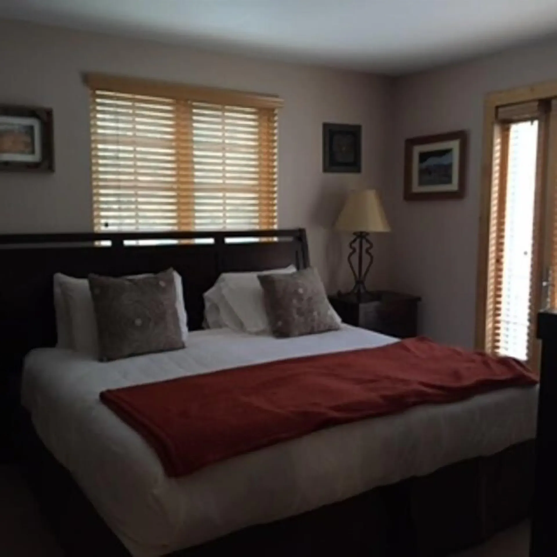 A bedroom with a large bed and a lamp