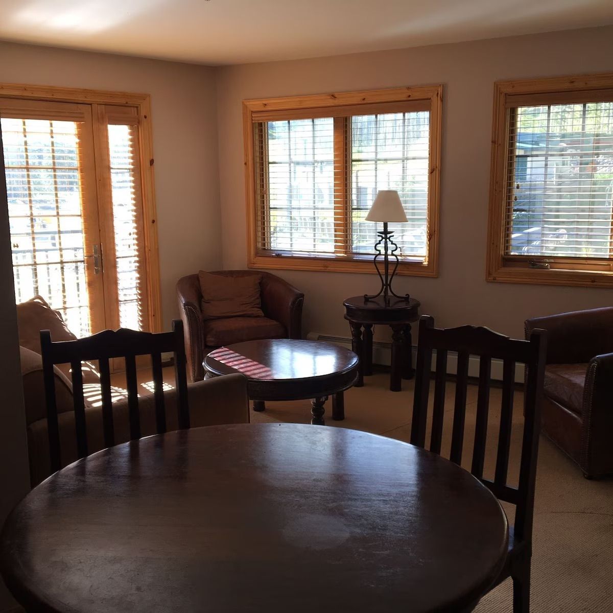 A living room with a table and chairs and a lamp