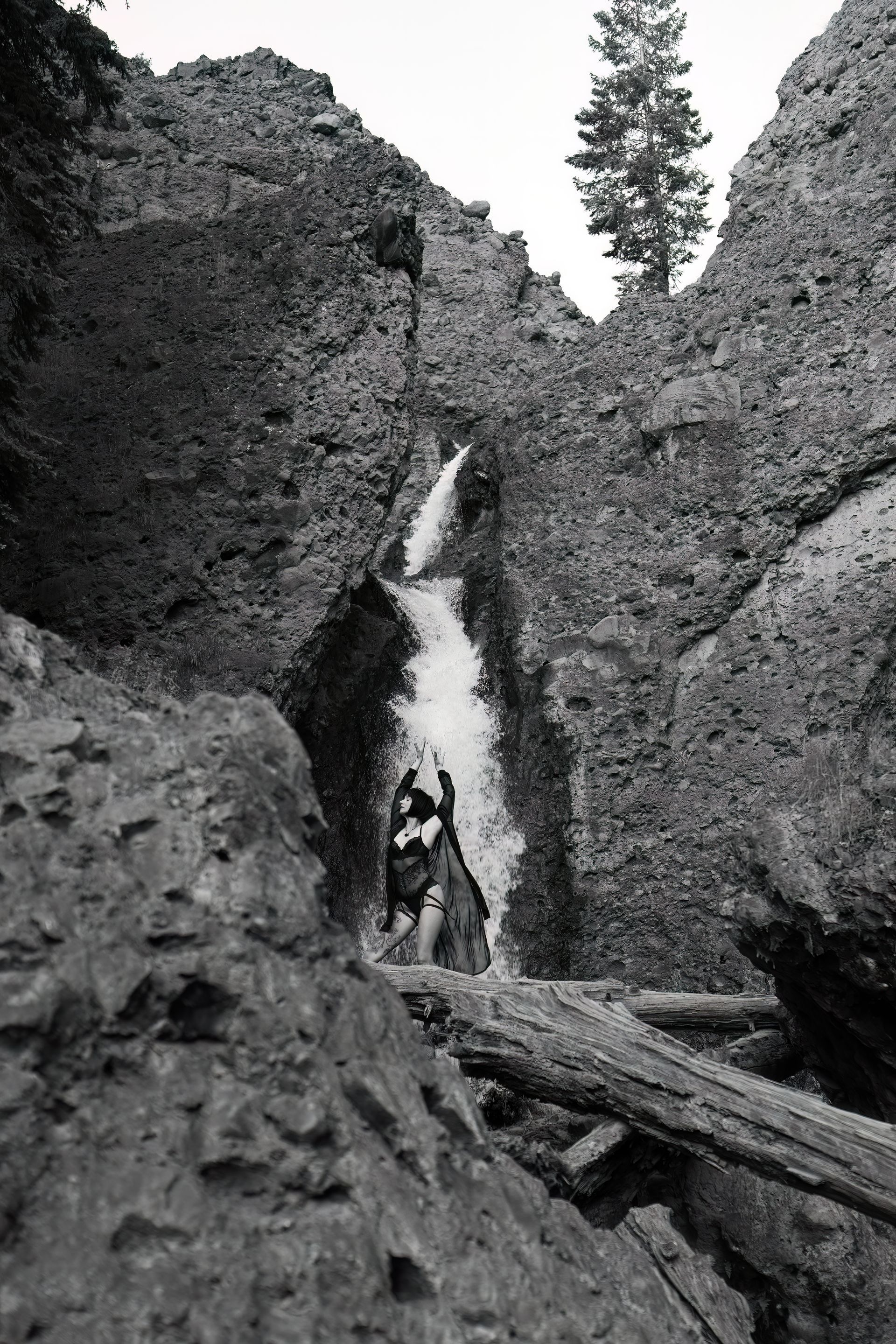 A black and white photo of a waterfall in the mountains