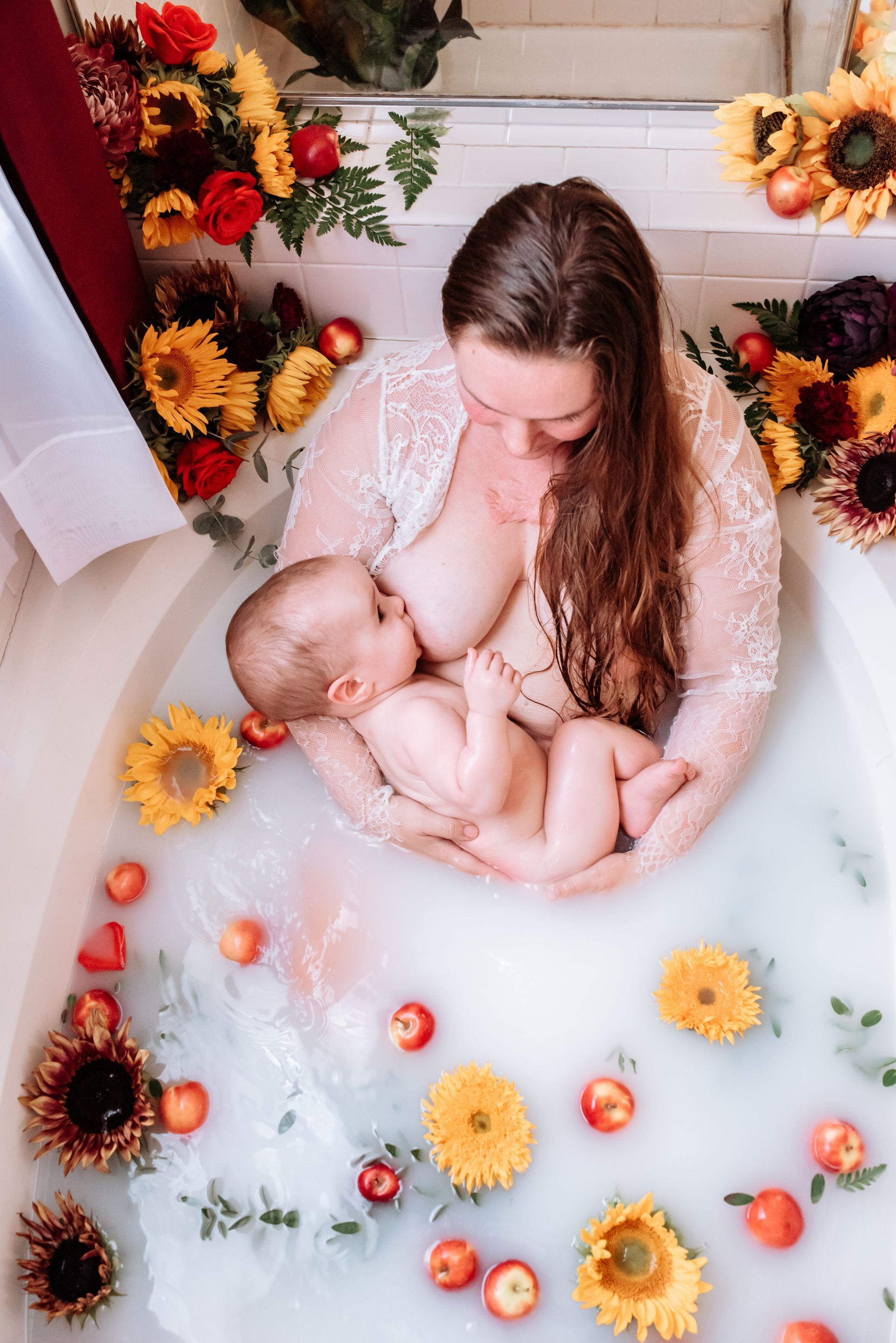 A woman nursing a baby in a milk bath.