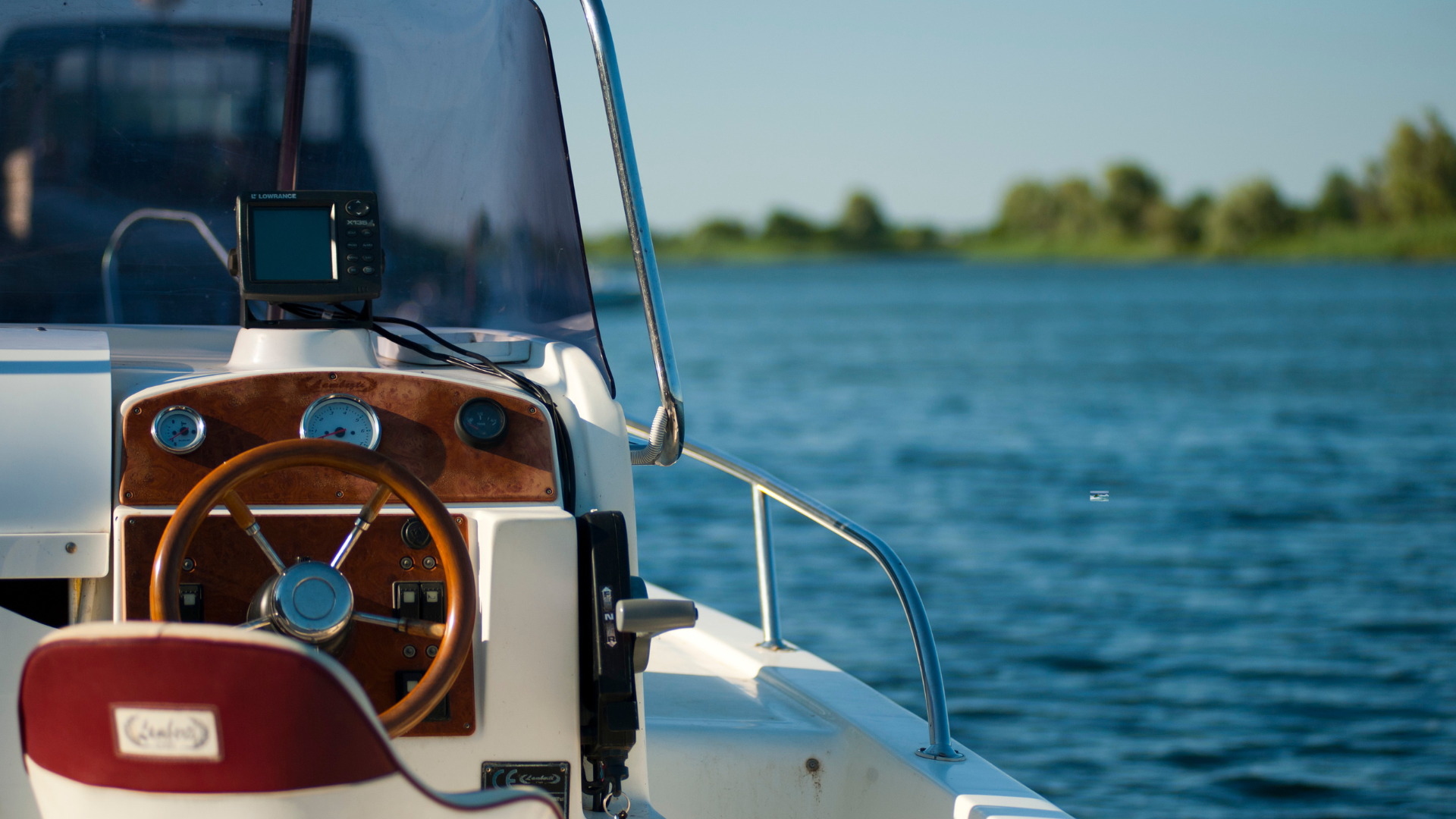 A hummingbird gps is sitting on the dashboard of a boat.