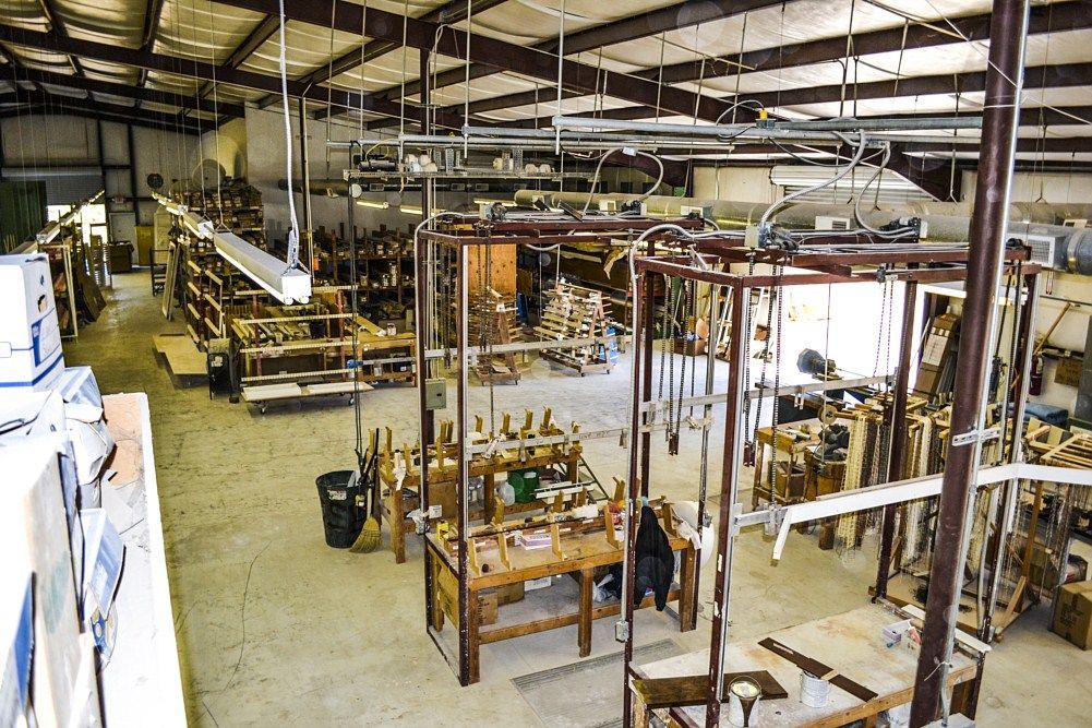 A large warehouse filled with lots of wooden tables and chairs.
