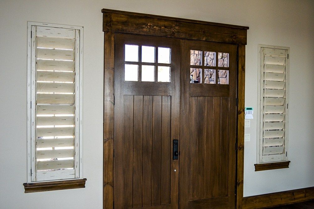 A wooden door with shutters on the side of it