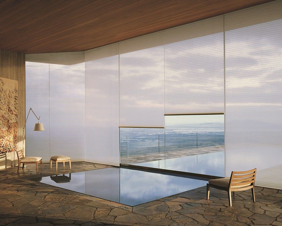 A room with a swimming pool and a view of the ocean.