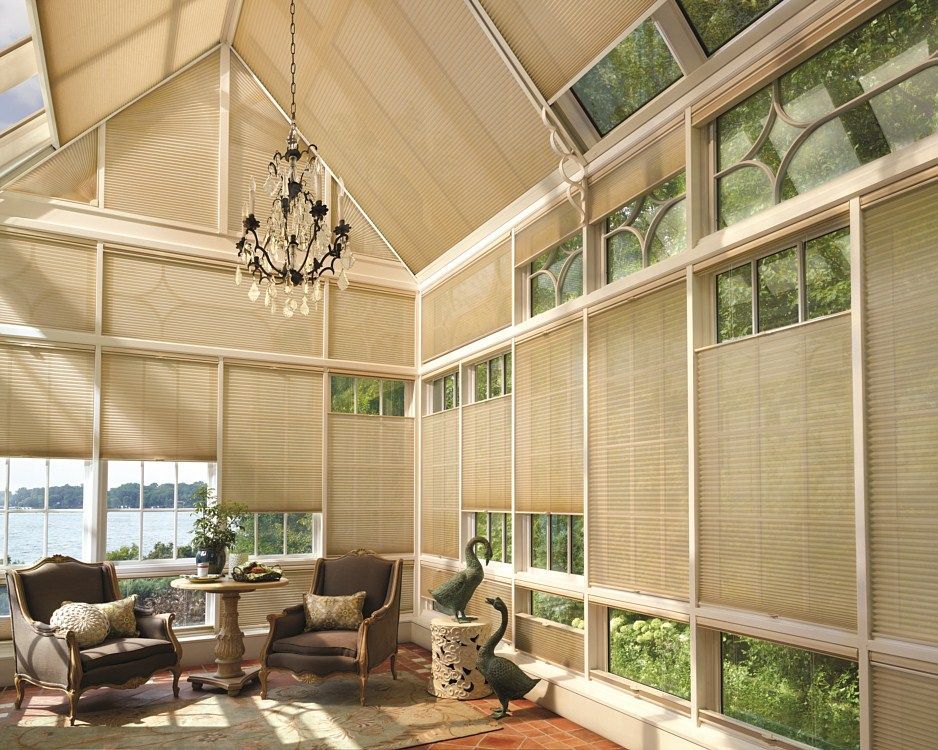 A living room with lots of windows and a chandelier.