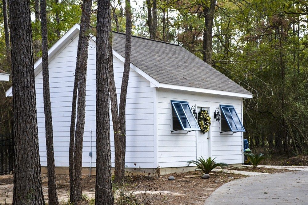 A small white house in the middle of a forest