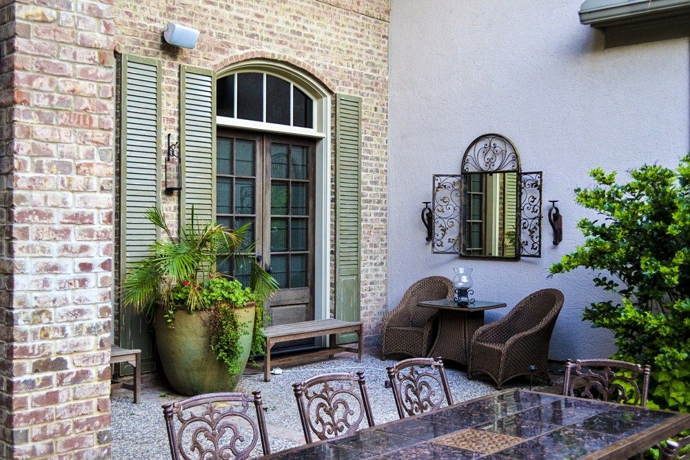 A patio with a table and chairs in front of a brick building.