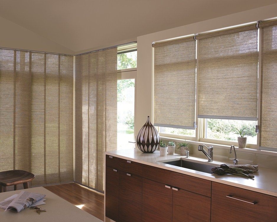 A kitchen with a sink , cabinets , and blinds on the windows.