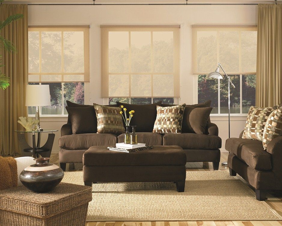 A living room with a brown couch and ottoman