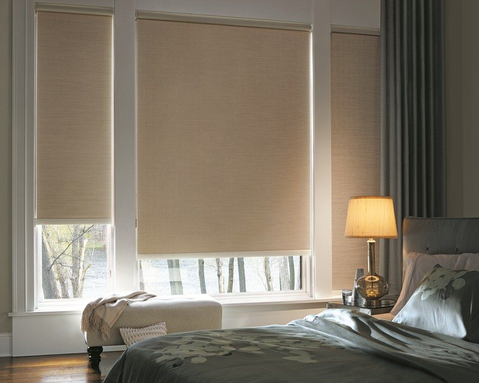 A bedroom with a bed , a lamp , and a window with blinds.