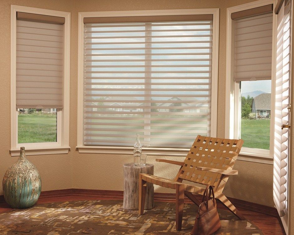 A living room with a chair and a window with blinds.