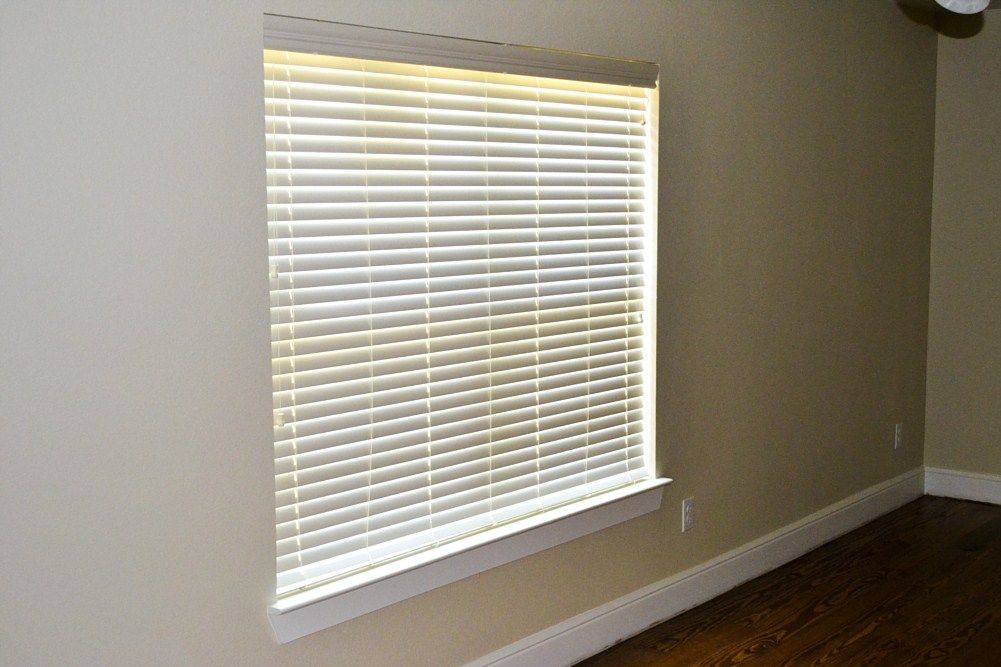 An empty room with a window with blinds on it.