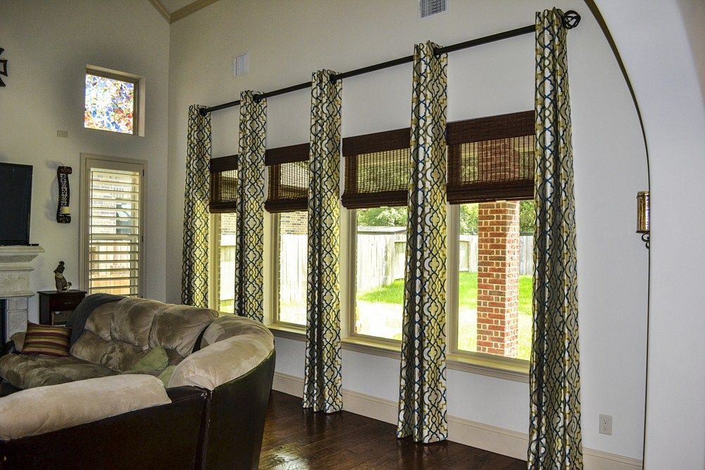 A living room with a lot of windows and curtains
