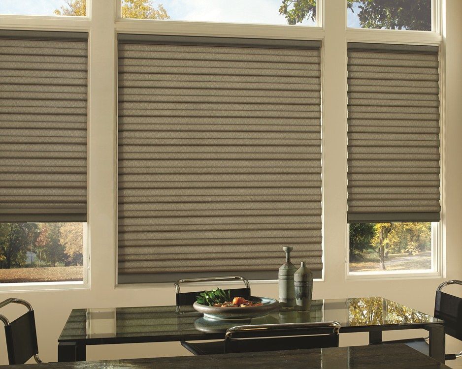 A dining room with a table and chairs and a window with blinds