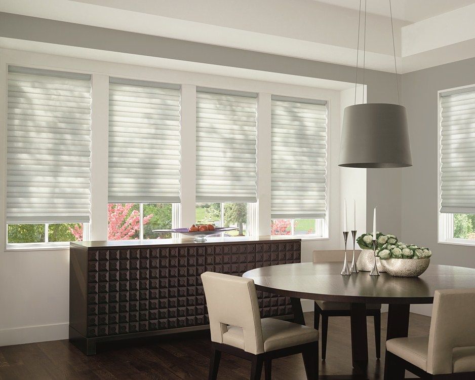 A dining room with a table and chairs and blinds on the windows.