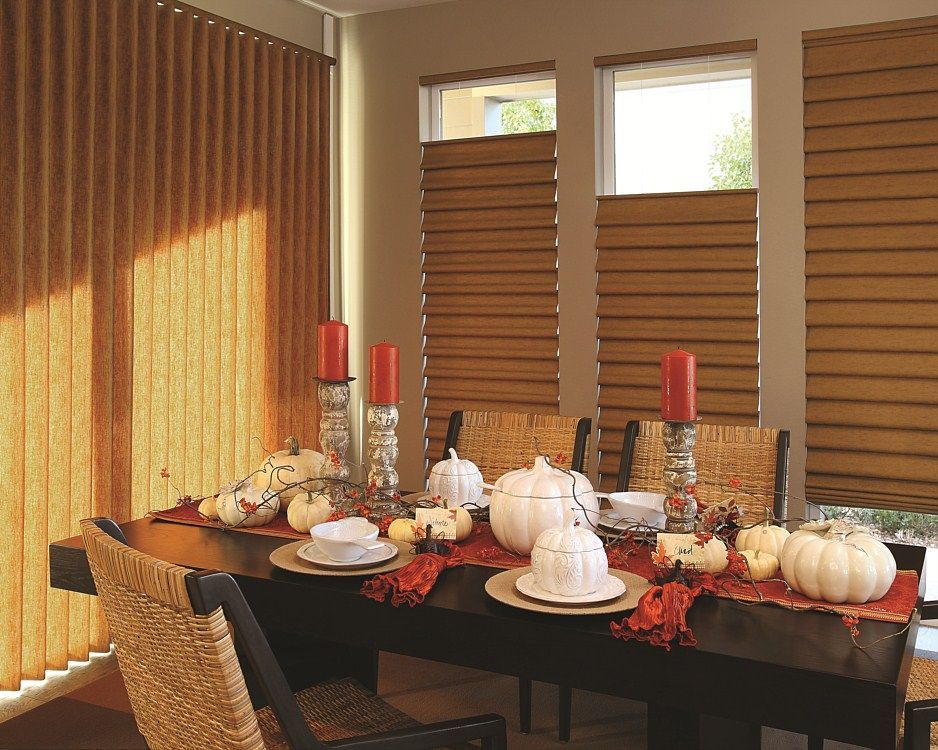 A dining room table with pumpkins and candles on it