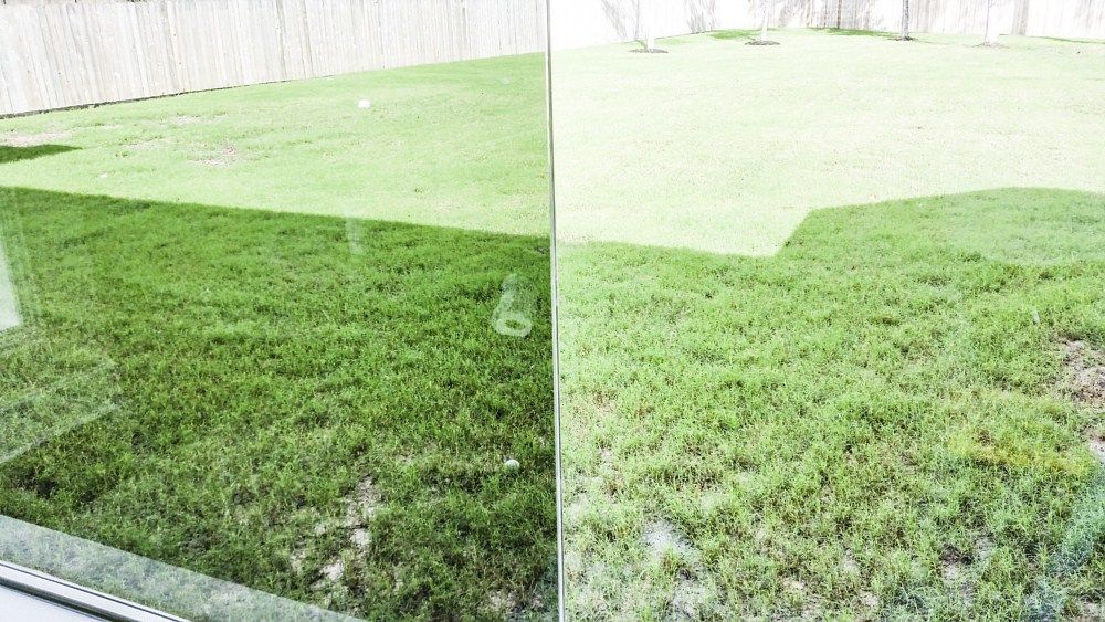 A reflection of a lush green field of grass in a window.