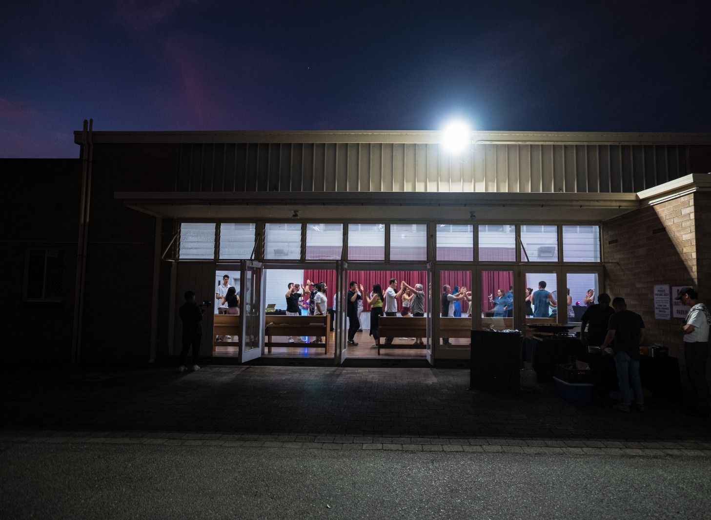 A man is holding a woman in his arms while dancing in a dance studio.