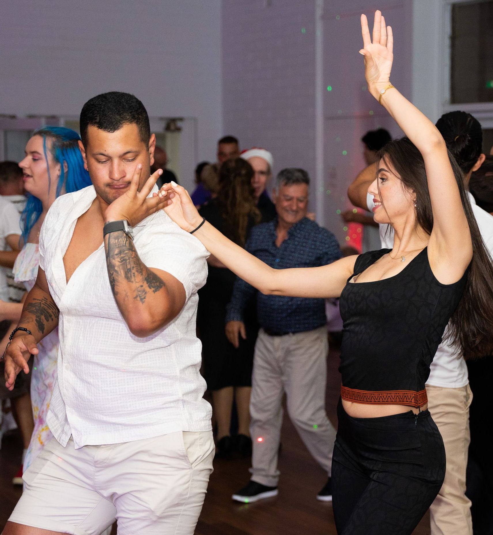 A man and a woman are dancing together at a party