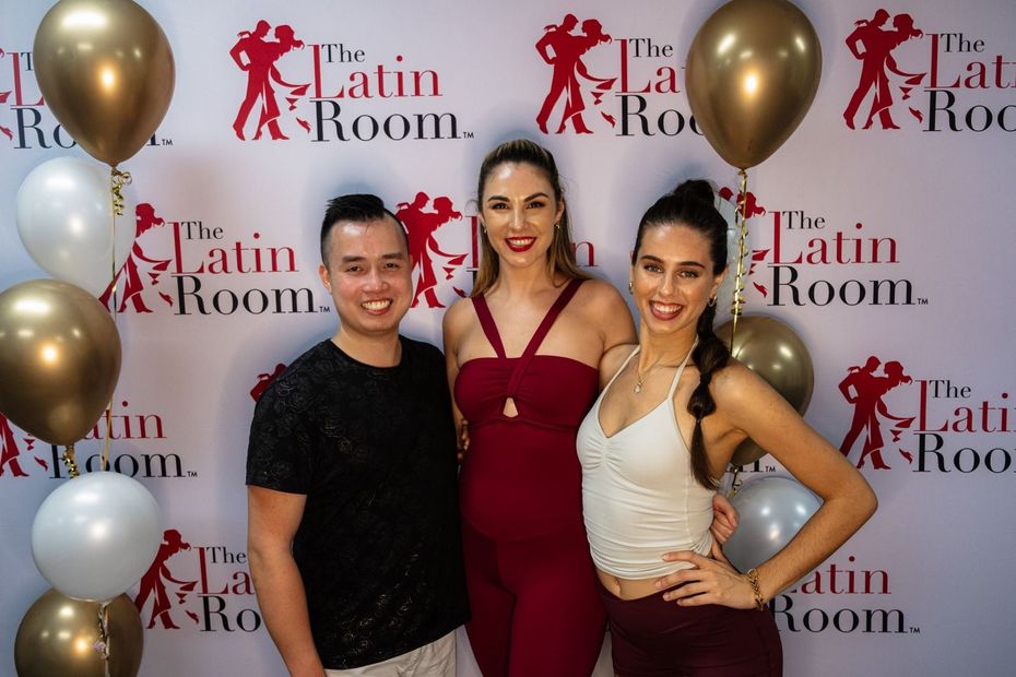 A man is holding a woman in his arms while dancing in a dance studio.