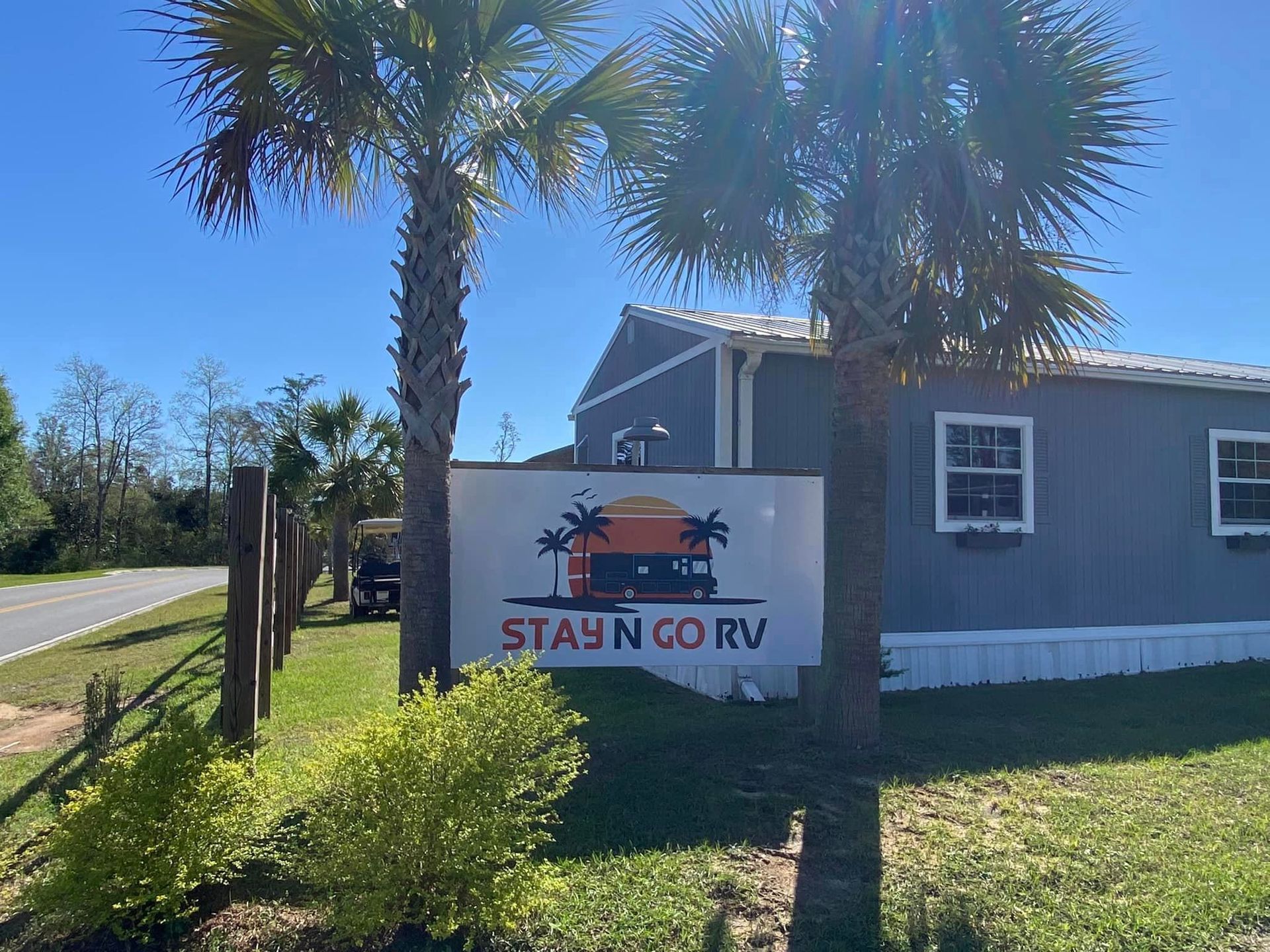A mobile home with a sign in front of it that says `` stay n go rv ''.