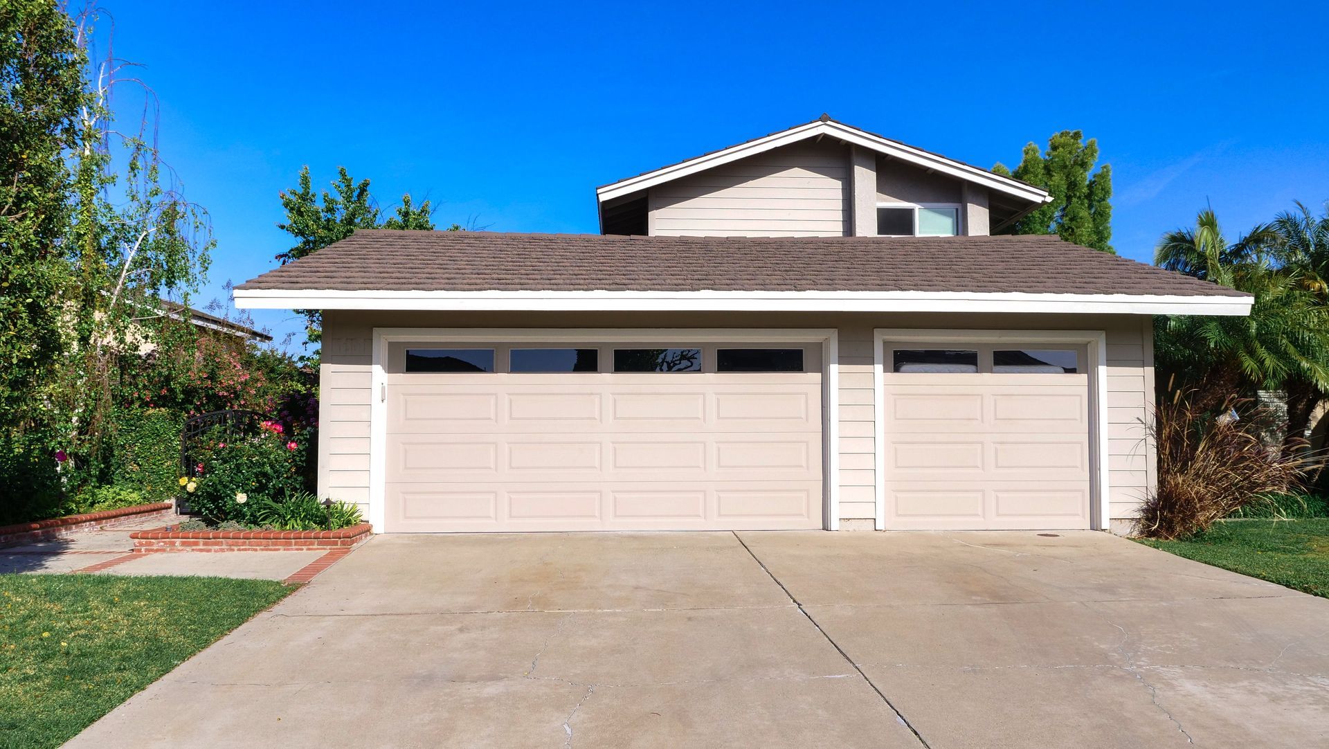 A house with three garage doors and a concrete driveway