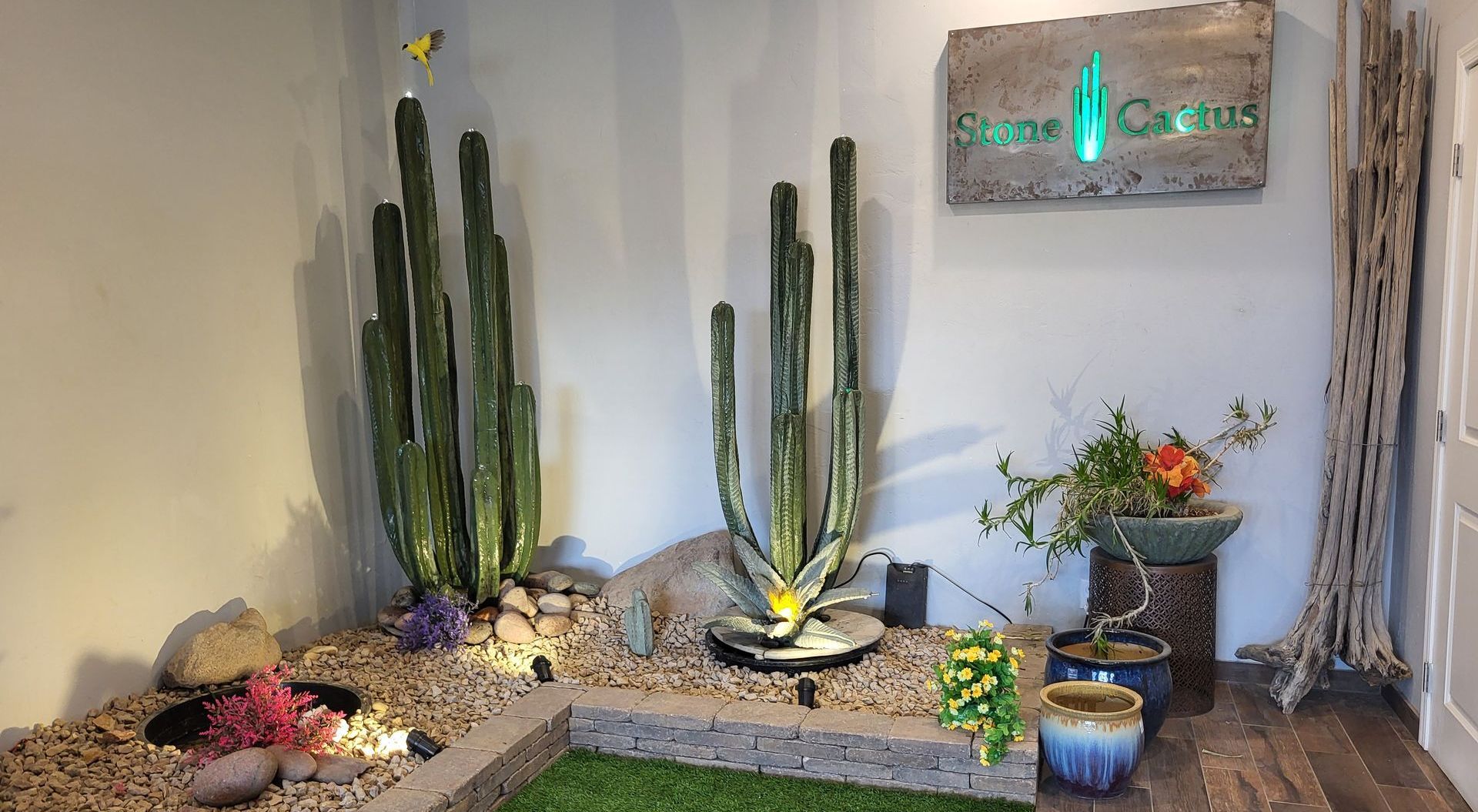 A room with cactus plants and a sign on the wall.